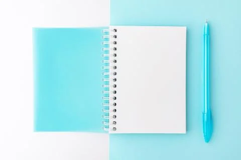 Top view of opened light blue cover spiral notepad with pen on blue and white Stock Photos