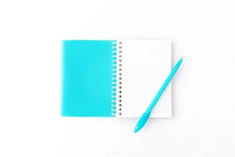 Top view of opened light blue cover spiral notepad with pen on white desk Stock Photos