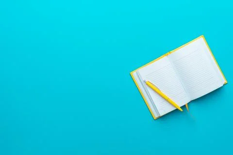Top view of opened notebook and pen on turquoise blue background with copy space Stock Photos