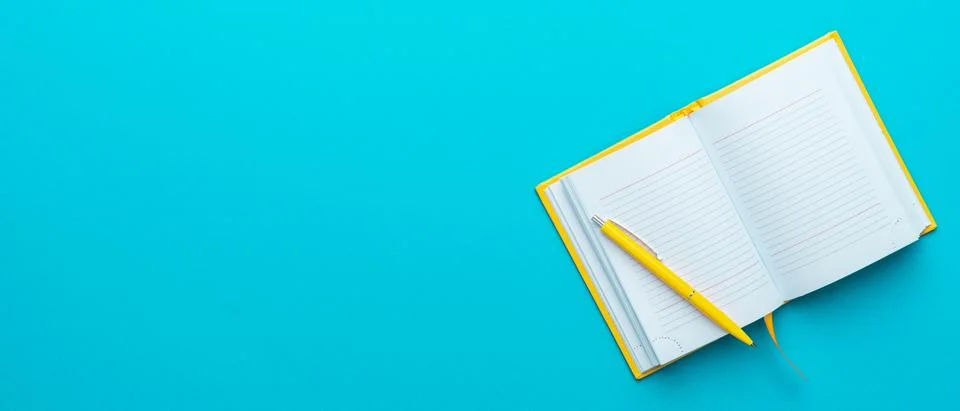 Top view of opened notebook and pen on turquoise blue background with copy space Foto stock
