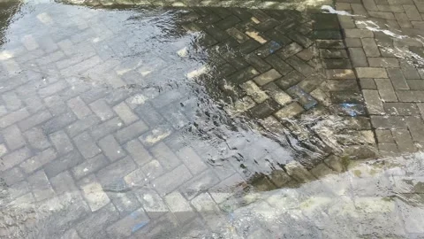 Top view or flat lay view of shallow water flow on grey paved background Stock Footage 293784279