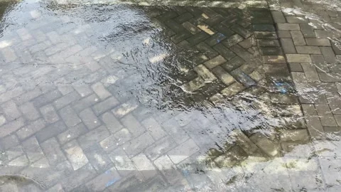 Top view or flat lay view of shallow water flow on grey paved background Stock Footage 293784644