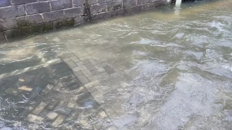 Top view or flat lay view of shallow water flow on grey paved background Stock Footage 295491770