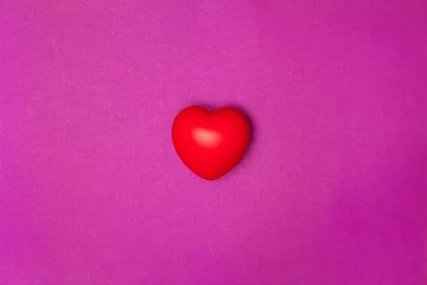Top view or flat lay of red heart pillow on purple background with copy space Stock Photos
