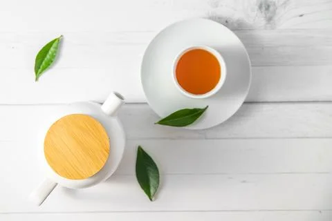 Top view or flatlay with herbal tea in a cup and teapot on white wooden Stock Photos