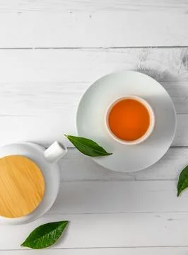 Top view or flatlay with herbal tea in a cup and teapot on white wooden Foto stock