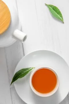 Top view or flatlay with herbal tea in a cup and teapot on white wooden Foto stock