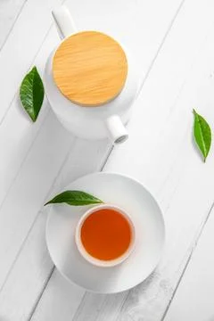 Top view or flatlay with herbal tea in a cup and teapot on white wooden Stock Photos