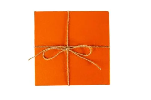 Top view of orange square box tied with brown rope bow on white background Stock Photos