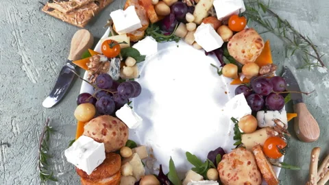 Top view of an oval ceramic plate with sausage, cheese and vegetable appetizers  Stock Footage 304458768