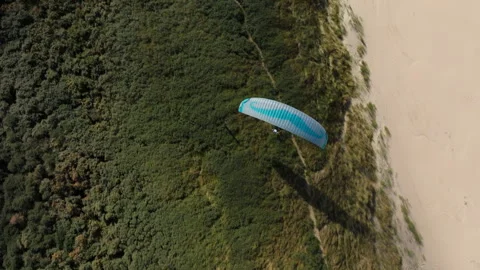 Top view over paraglider soaring along vegetated Dutch coastal dune Stock Footage 327341585