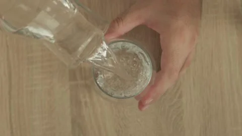 Top view overhead shot of man pouring fresh water into glass cup 4k Stock Footage 343450253