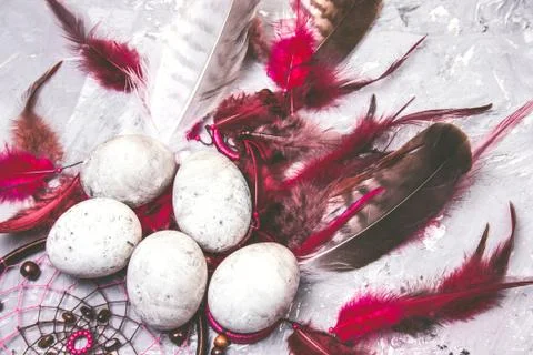 Top view painted easter eggs with stone effect and bright feathers Stock Photos