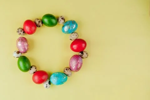 Top view painted eggs Easter Frame in circle shape on a yellow background. Co Stock Photos