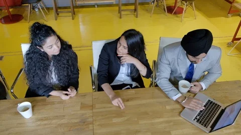 Top view pan left to right and back of friends and colleagues discussing and wor Stock Footage 104586440