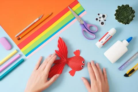 Top view of paper cutting tools, scissors, cutter, female hands holding finis Stock Photos