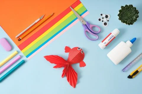 Top view of paper cutting tools, scissors, cutter and red fish paper crafts.  Stock Photos