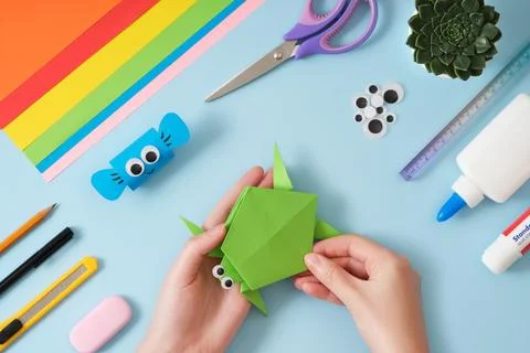 Top view of paper cutting tools, scissors, cutter, female hands holding finis Stock Photos