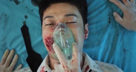 Top view of paramedics hands putting on guy face oxygen inhalation mask and Video stock 139152747