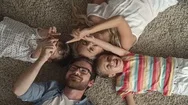 Top View Of Parents And Their Little Kids Lying On The Floor At Home And Playing Stock Footage
