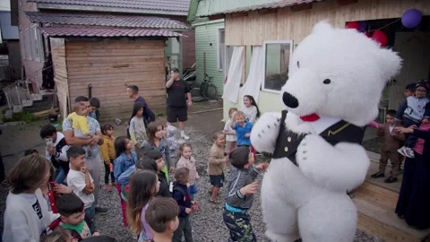 Top-view of a party for a crowd of children with animator dressed as polar bear Stock Footage 251556401