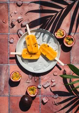 Top view passion fruit popsicles on terra cotta tile in sun. Stock Photos