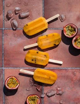 Top view passion fruit popsicles on terra cotta tile in sun. Stock Photos
