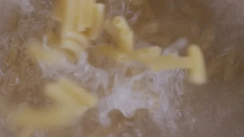 Top view of pasta falling into pot of boiling water 스톡 동영상 255007059