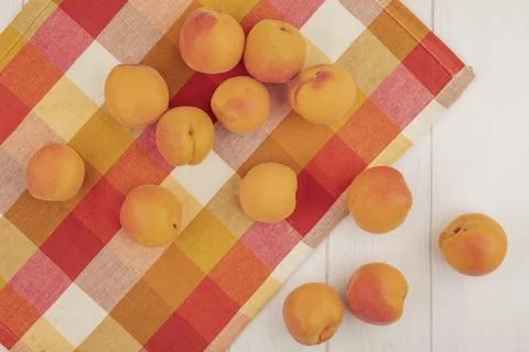Top view of pattern of apricots on plaid cloth and on wooden background Stock Photos
