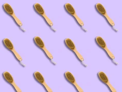 Top view pattern brush for dry skin massage on a pastel violet background,cop Stock Photos