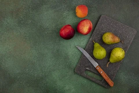 Top view of pattern of fruits as pears with knife on cutting board and peac.. Stock Photos