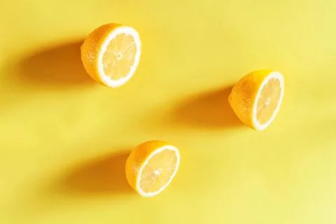 Top view of pattern, halves of juicy lemons are laid out in triangle on yello Stock Photos