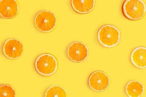 Top view of pattern, laid out slices of juicy oranges on yellow background. S 스톡 사진