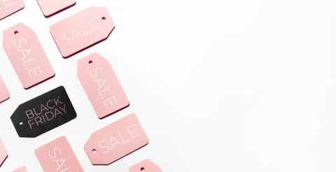 Top view on pattern of many pink and one black clothes tags on white backgrou Stock Photos