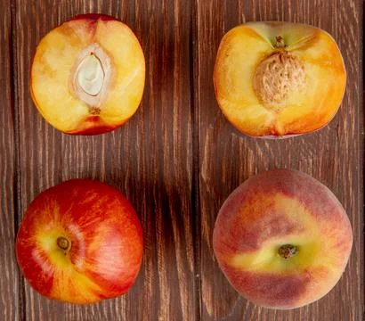 Top view of pattern of whole and half cut peaches on wooden background Stock Photos