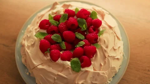 Top view of pavlova meringue cake with raspberries and mint leaves Stock Footage 320197697