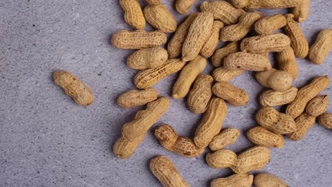 Top view of peanuts fall scattered onto the wooden table Stock Footage 275248374