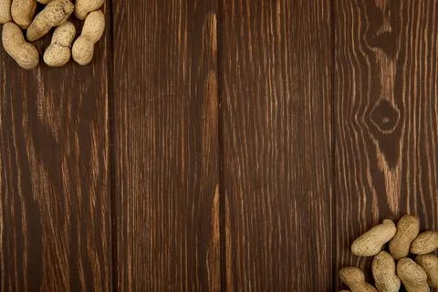 Top view of peanuts in shell scattered on wooden background with copy space Stock Photos