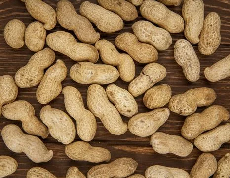 Top view of peanuts in shell scattered on wooden background Stock Photos