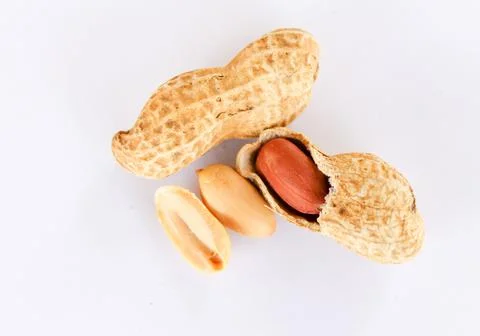 Top view of peanuts on a white background. Peanuts are shelled to reveal red  Stock Photos
