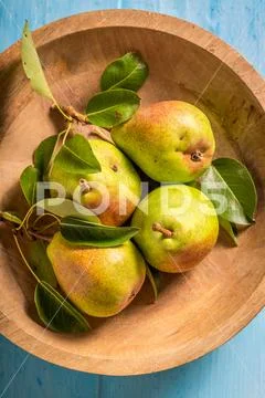 Top view of pears in brown bowl on blue table Stock Photos