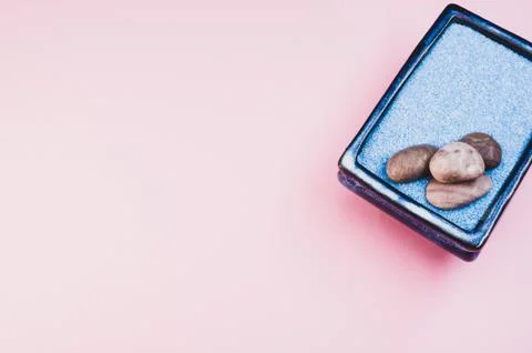 A top view of pebbles on a rectangular box filled with small blue rocks on pi Foto stock