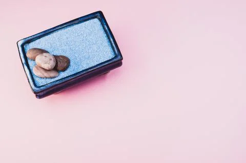A top view of pebbles on a rectangular box filled with small blue rocks on pi Foto stock