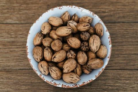 Top view of pecan nuts in a white bowl on wooden table Stockfoto's
