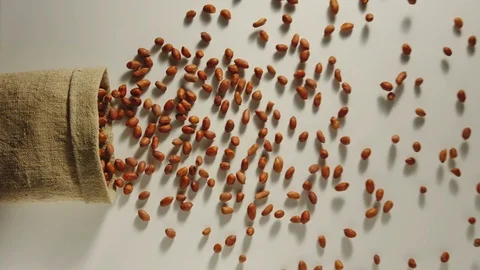 TOP VIEW: Peeled peanuts are poured out from a sack - Slow Motion Vídeos de archivo 98726504