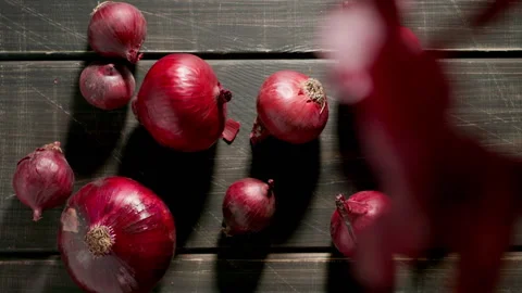 TOP VIEW: Peels fall on a red onion bulbs on a wooden dark table Stock Footage 202065821