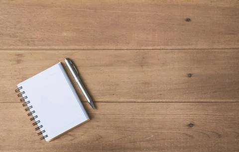 Top view of pen and notebook on wooden background and copy space for insert t Stock Photos