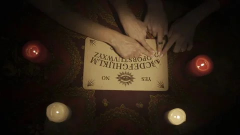Top view of a people hands moving together over the spirit ouija board game Stock Footage 248005485