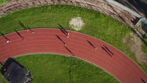 Top View of People Running on Running Track Creating Long Shadow Stock Footage 113431385