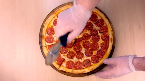 Top view of a pepperoni pizza being sliced on a wooden board Stockbeeldmateriaal 344172380